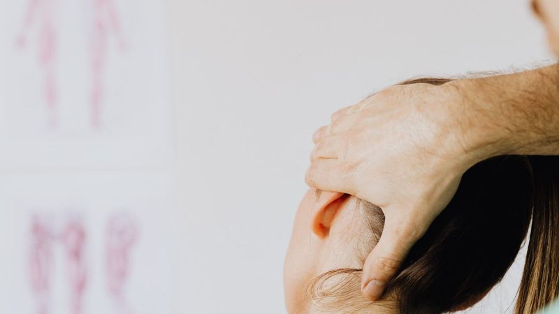 A chiropractor performing a hands-on neck adjustment
